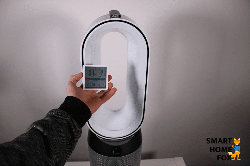 Uhrzeit und Temperatur vor dem Start der Heizlüfter-Funktion auf dem Thermostat. Im Hintergrund steht der Dyson Pure Hot and Cool HP04 Luftreiniger.